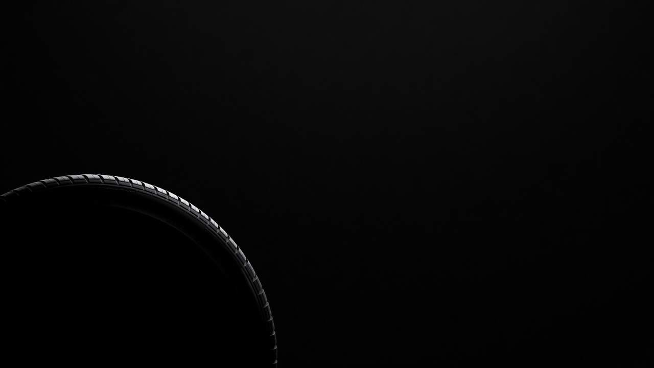 Concept render: a tyre tread emerging from black, the Requex wrap panel treatment